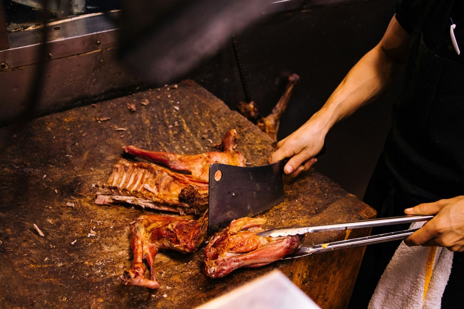 person holding knife and fork slicing meat